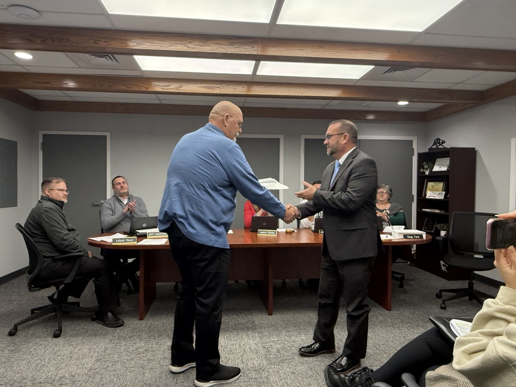 two men shaking hands at a board meeting