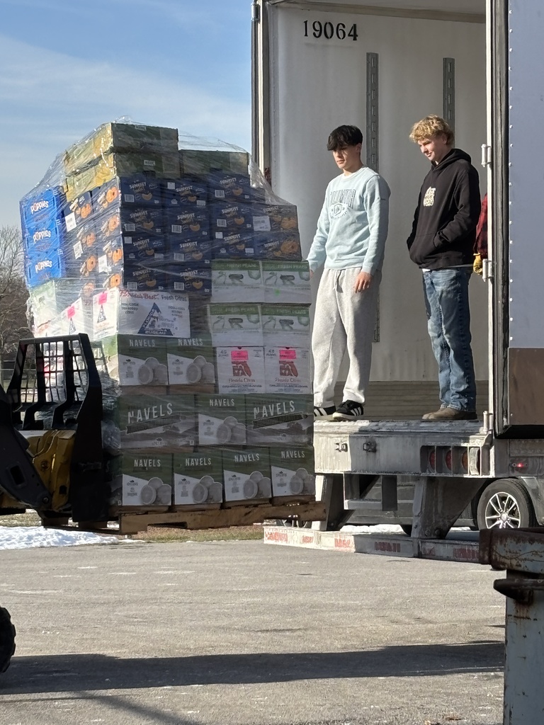 students getting a pallet of fruit off a truck