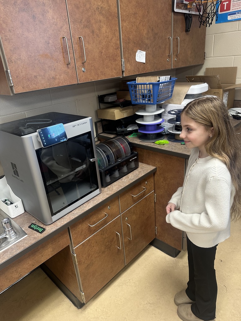 A student watching a 3 d printer print