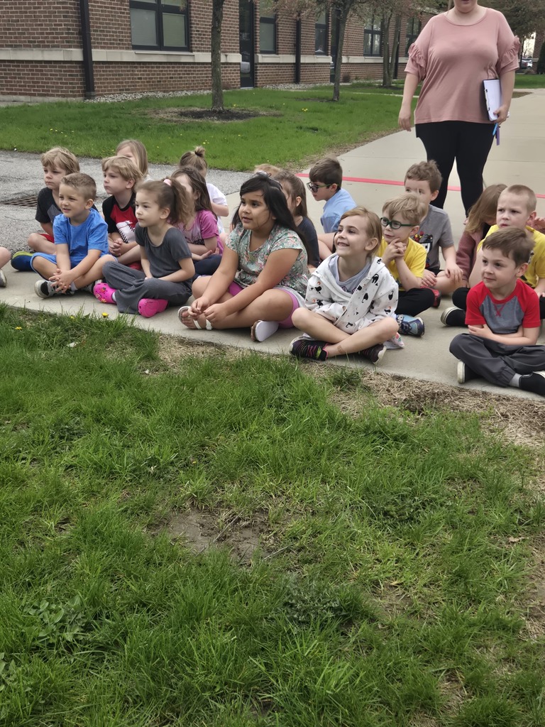 students sitting outside with a teacher