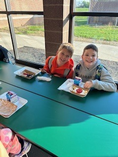 two students posing with their yogurt banana splits