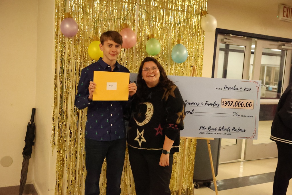 Student holding gift card in front of check