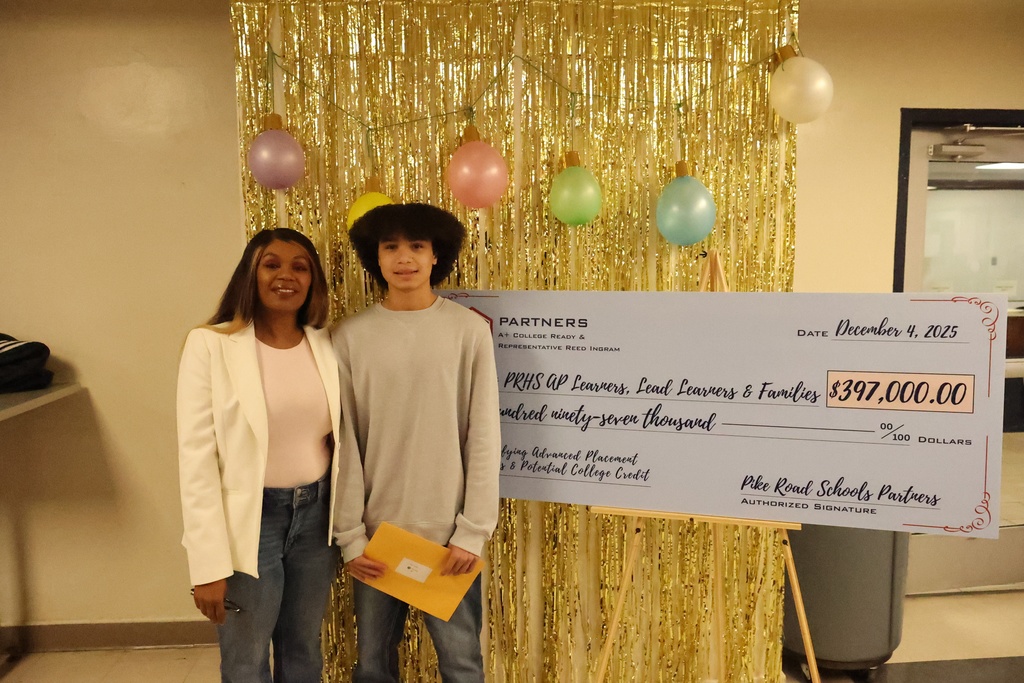 Student, with mom, holding gift card in front of check