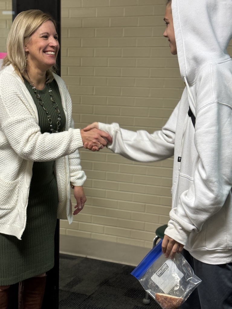 Allsion VanDriessche shaking a students hand
