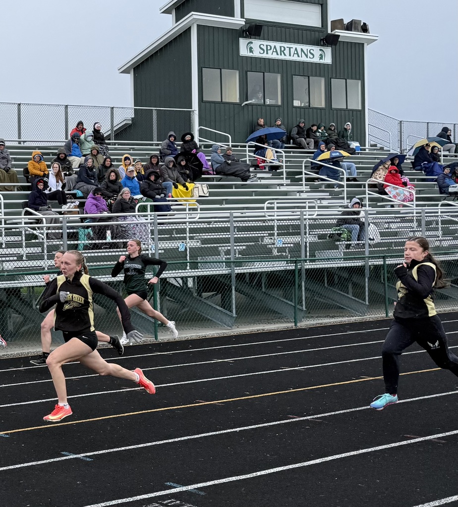 Girls sprinting in front of stands
