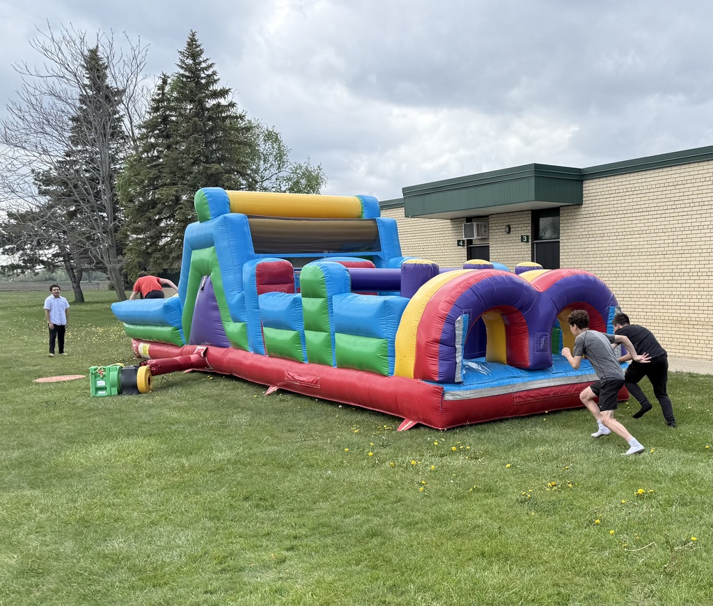 Two boys running into an inflatable obstacle course