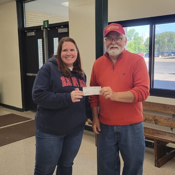 Picture of two people holding a check