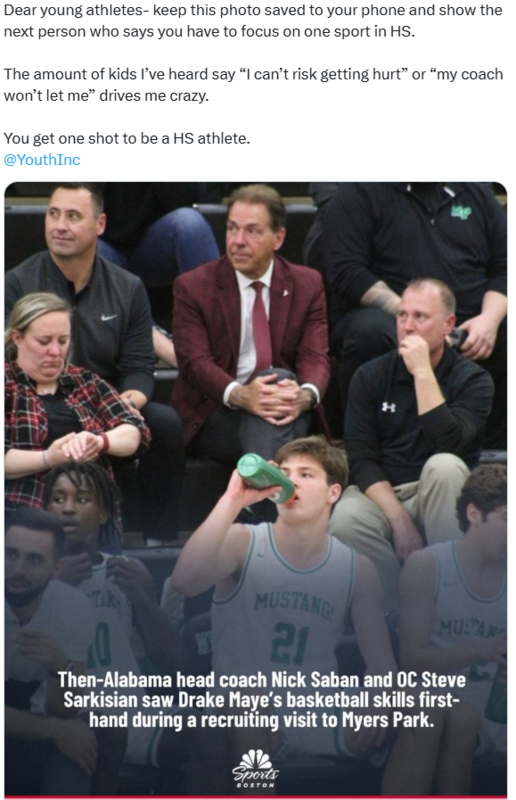 Coach sitting behind basketball player on the bench.