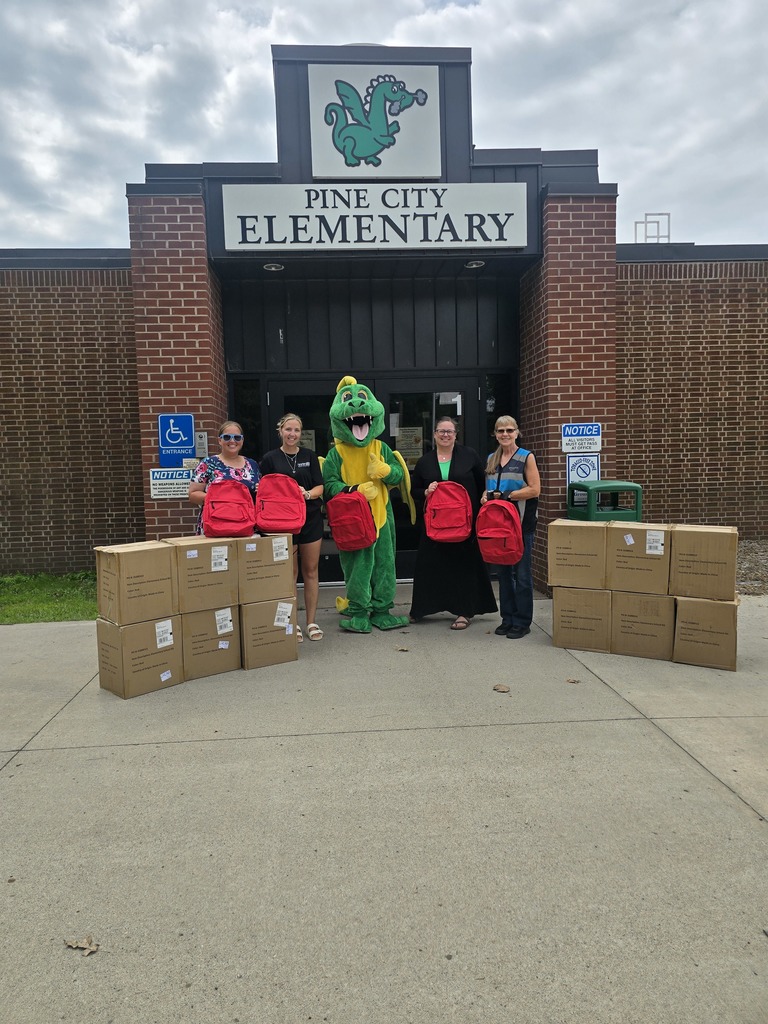 Dizzy Dragon and Pine City staff accepting donation of backpacks from Amazon for students