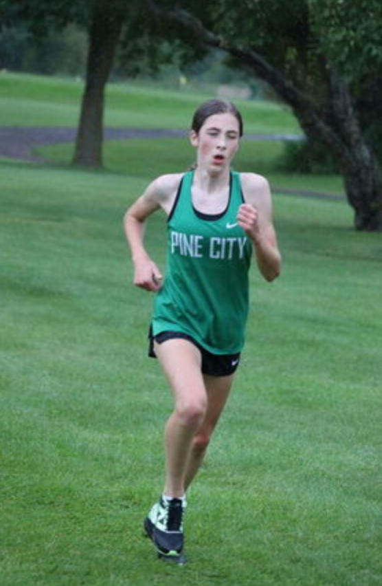 Cross Country runner wearing green Pine City jersey