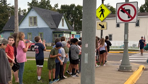 Sixth grades students standing along Main Street.