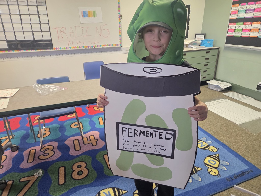 student in pickle costume holding sign with vocab word fermented
