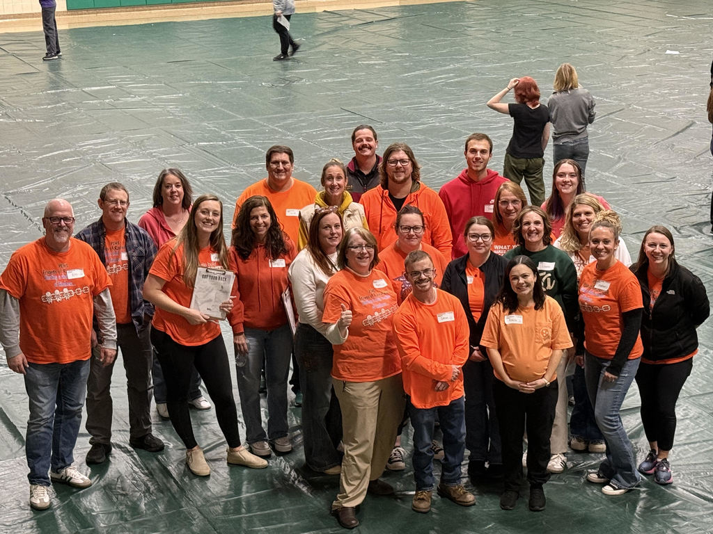 Adult volunteers in orange shirts as part of Rachel's Challenge. 