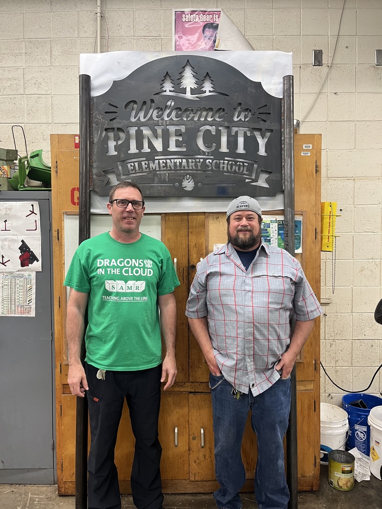 PCHS Teachers Schlichting & Eichten stand with the new Pine City Elementary sign they've designed and created. 