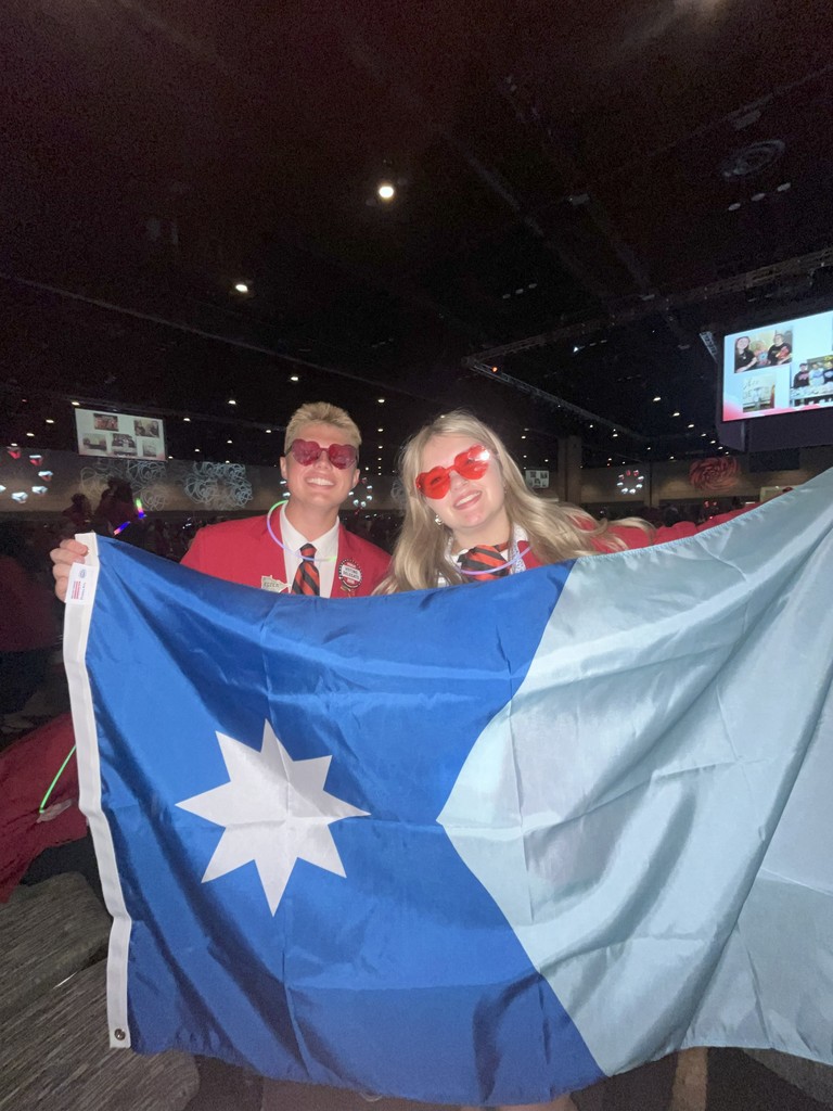 Two students holding the MN state flag.