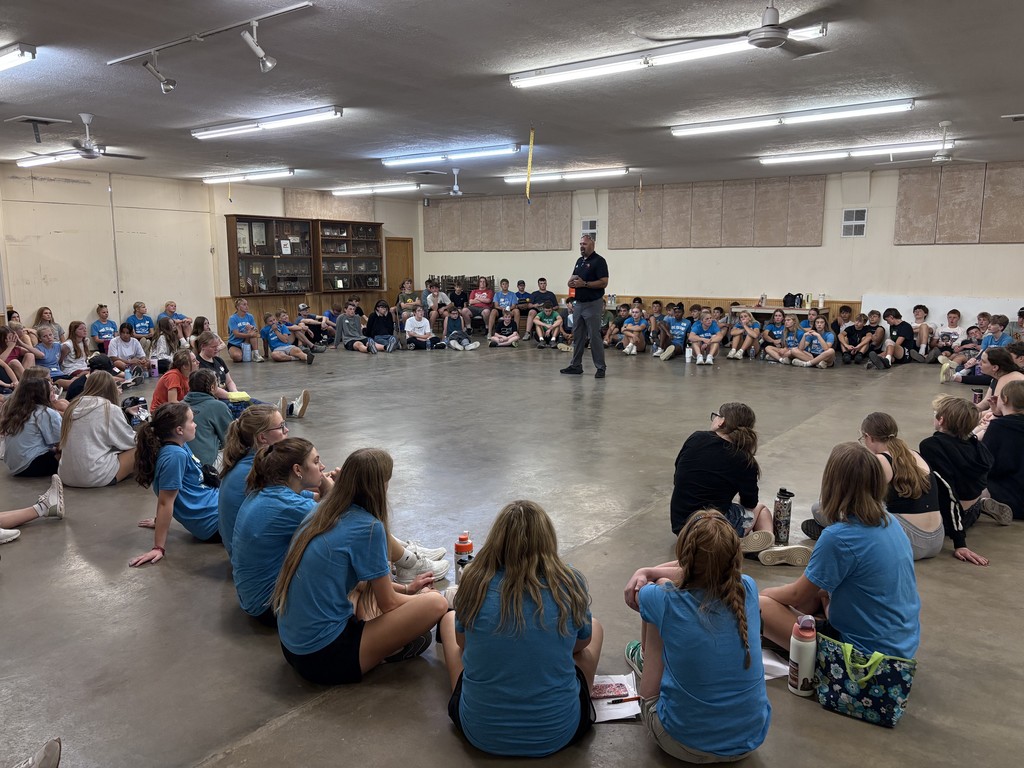 kids in circle listening to teacher