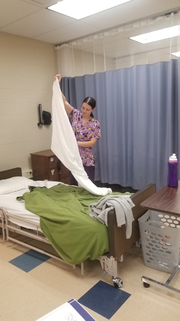 CNA student folding a blanket 
