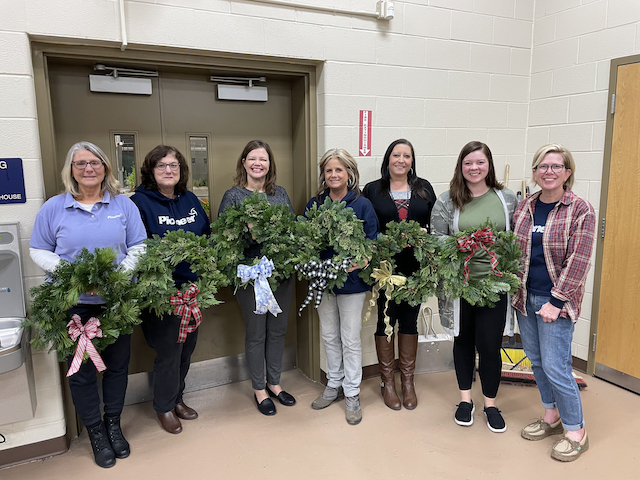 People holding wreaths 
