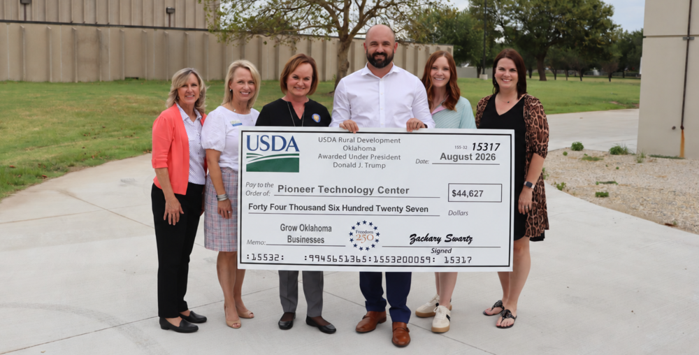 six individual holding a giant check from the USDA