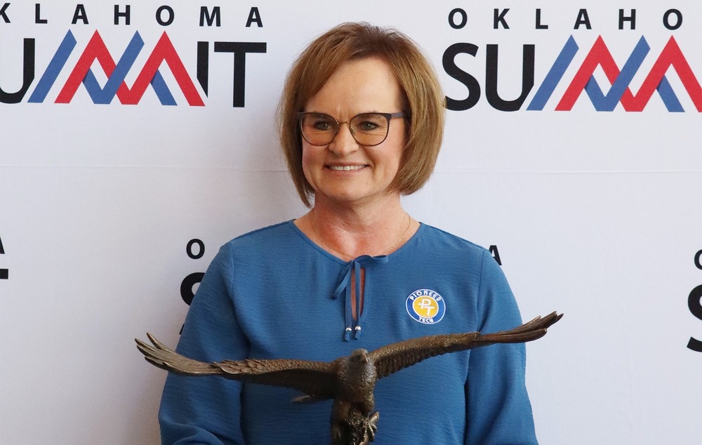 PTC Superintendent Traci Thorpe holding the Bob Funk Advocate of Excellence Award. The award is a bronze eagle with wings spread