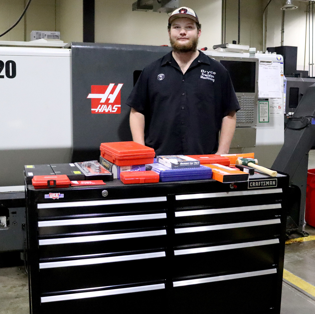 Pioneer Tech boy in hat with tool box in front of him. 