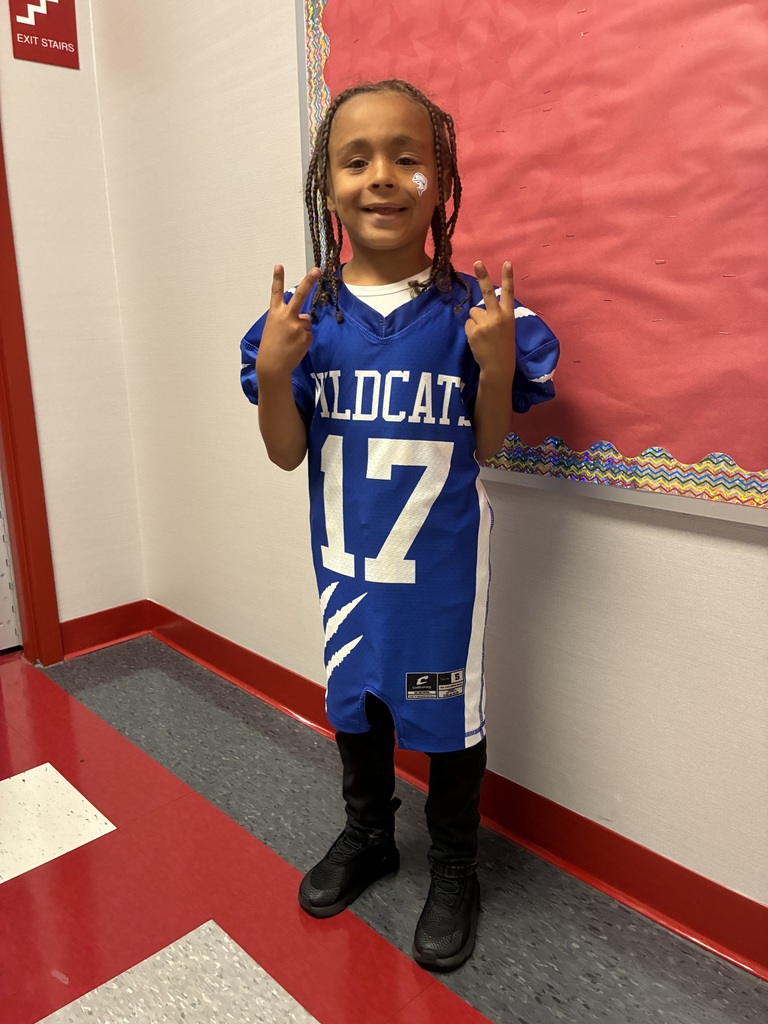 A wildcat football player in a football pose at school