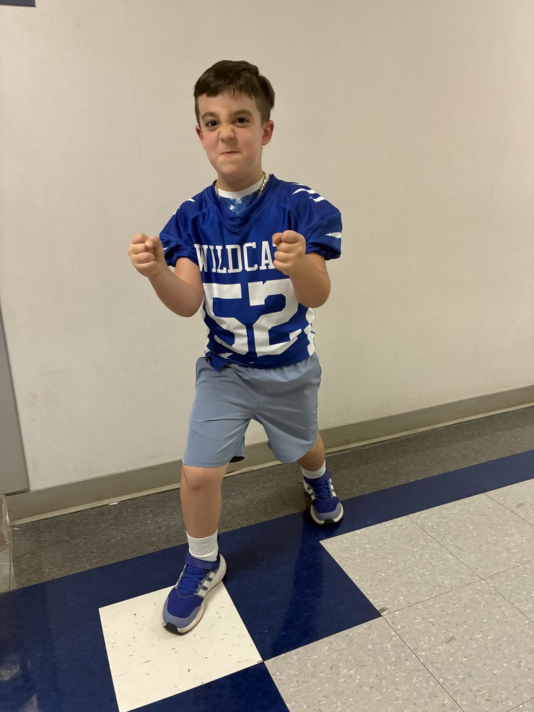 A wildcat football player in a football pose at school