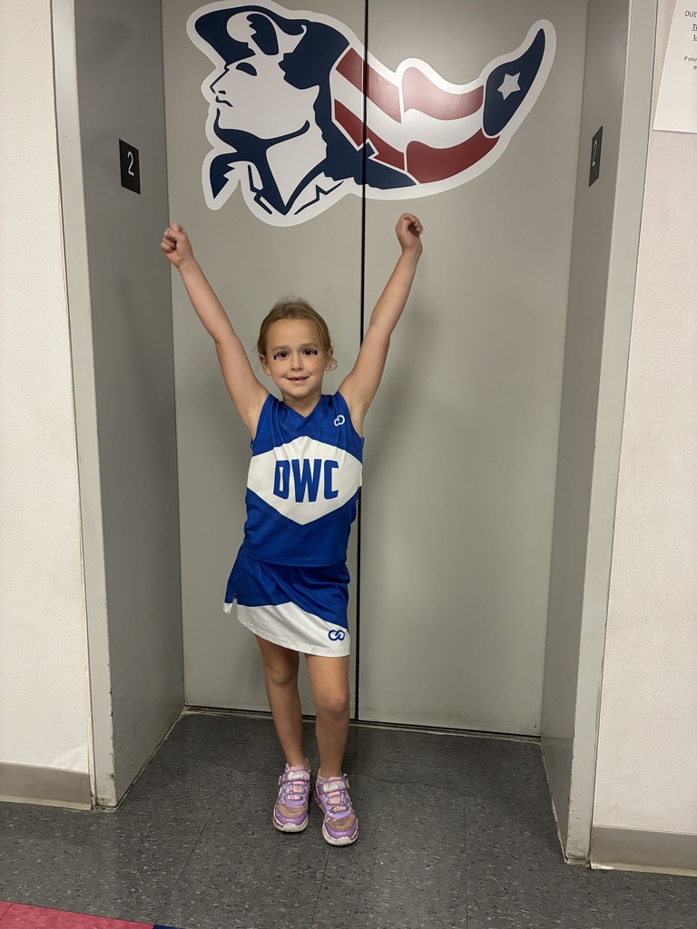 A wildcat cheerleader in a cheer pose at school