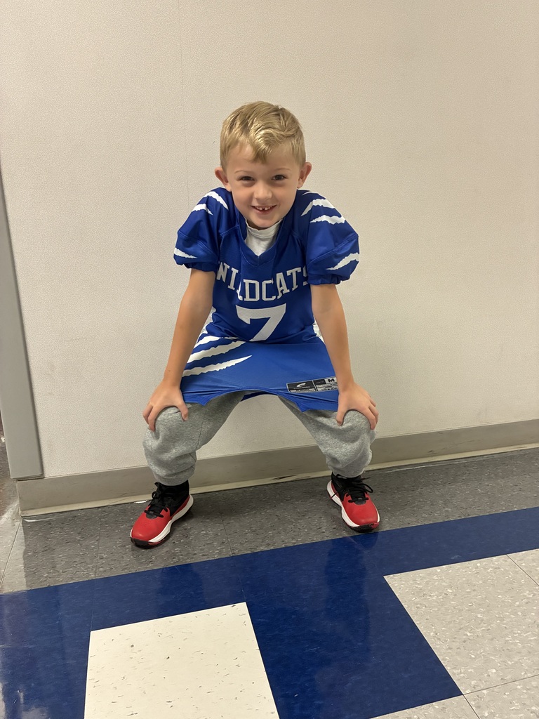 A wildcat football player in a football pose at school