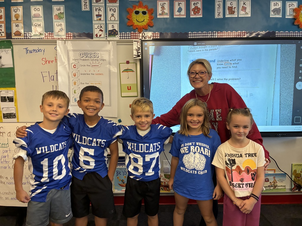 Mrs. Melvin and a group of her students dressed in their wildcats football gear