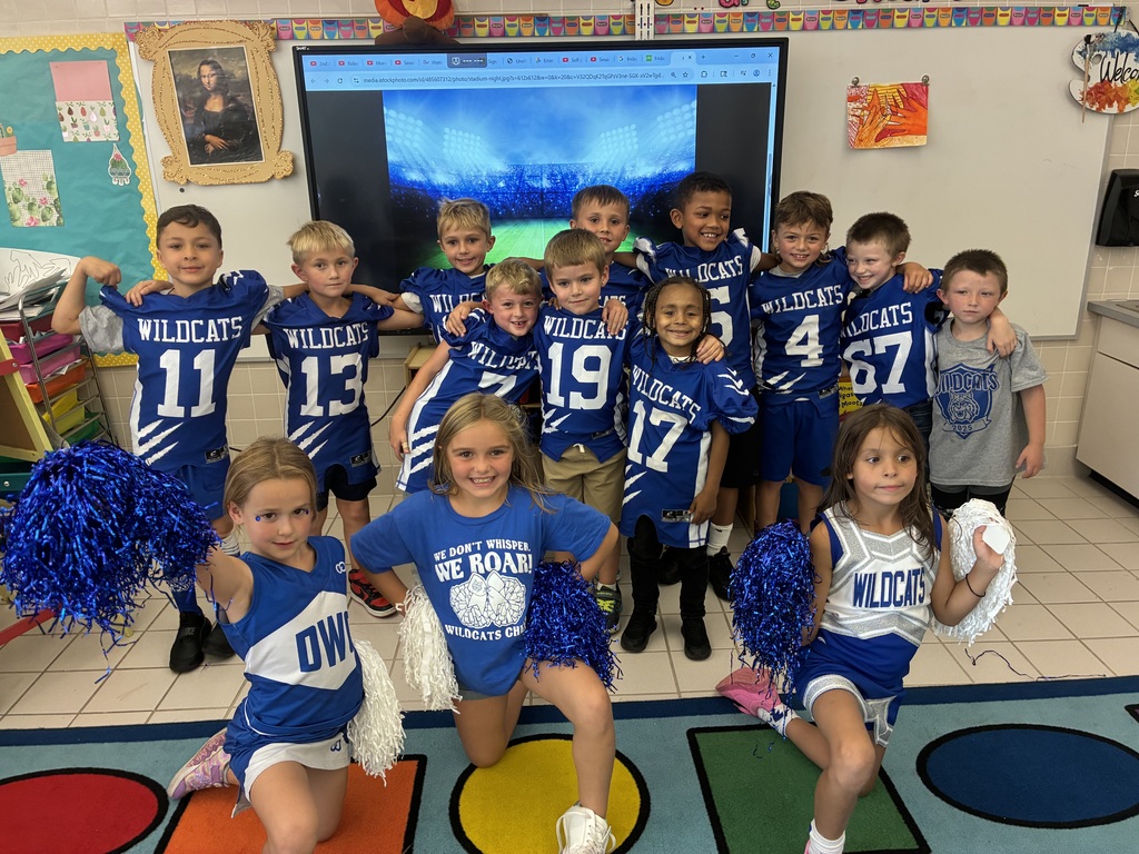 Primary students in a classroom in football uniforms, cheer uniforms and wildcat football t shirts. 