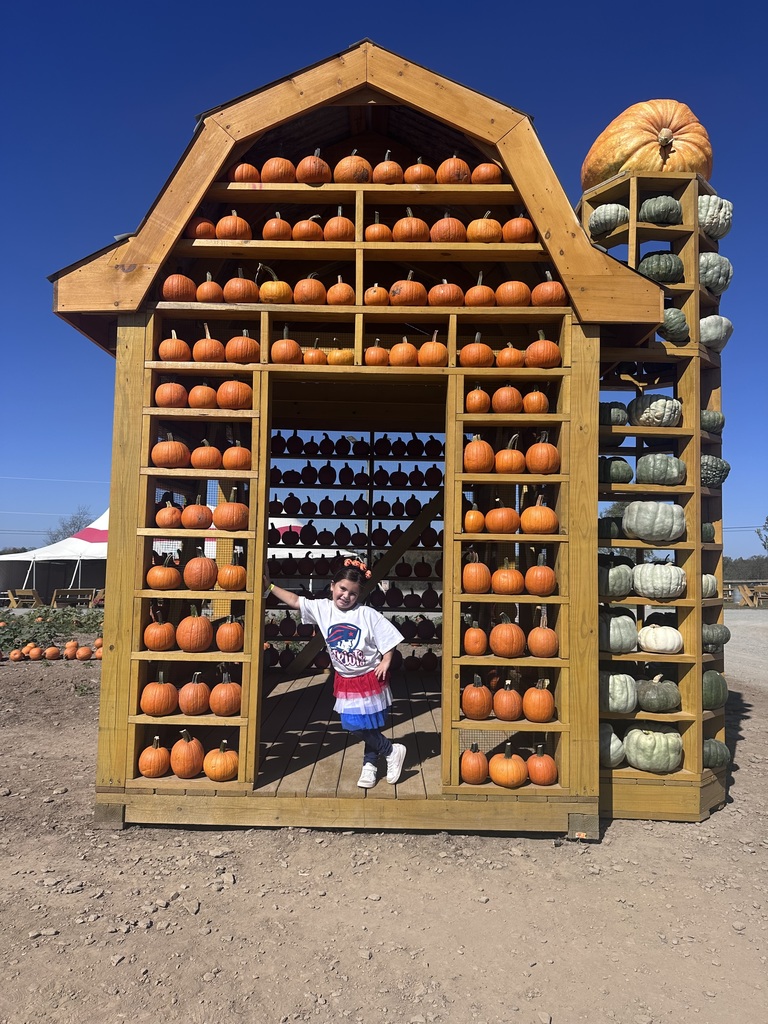 A girl posing in a pumpkin house.
