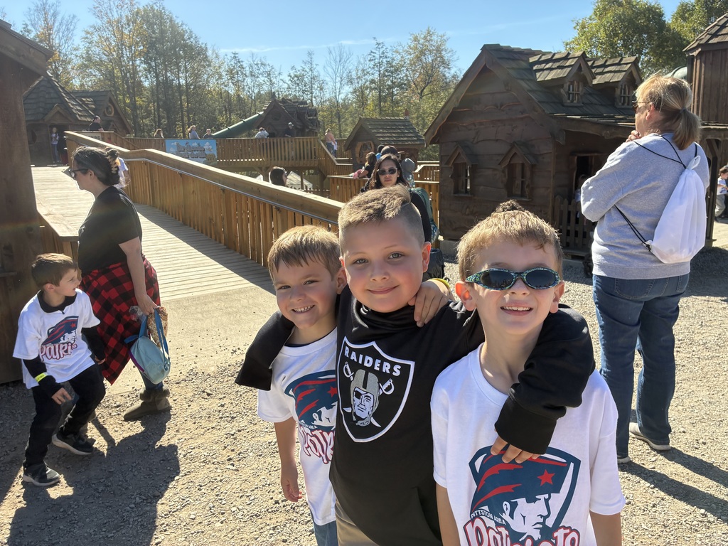 A group of boys smiling at the camera arms around each other.