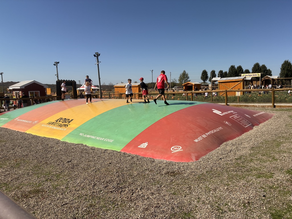 A group of students jumping on a inflatable.