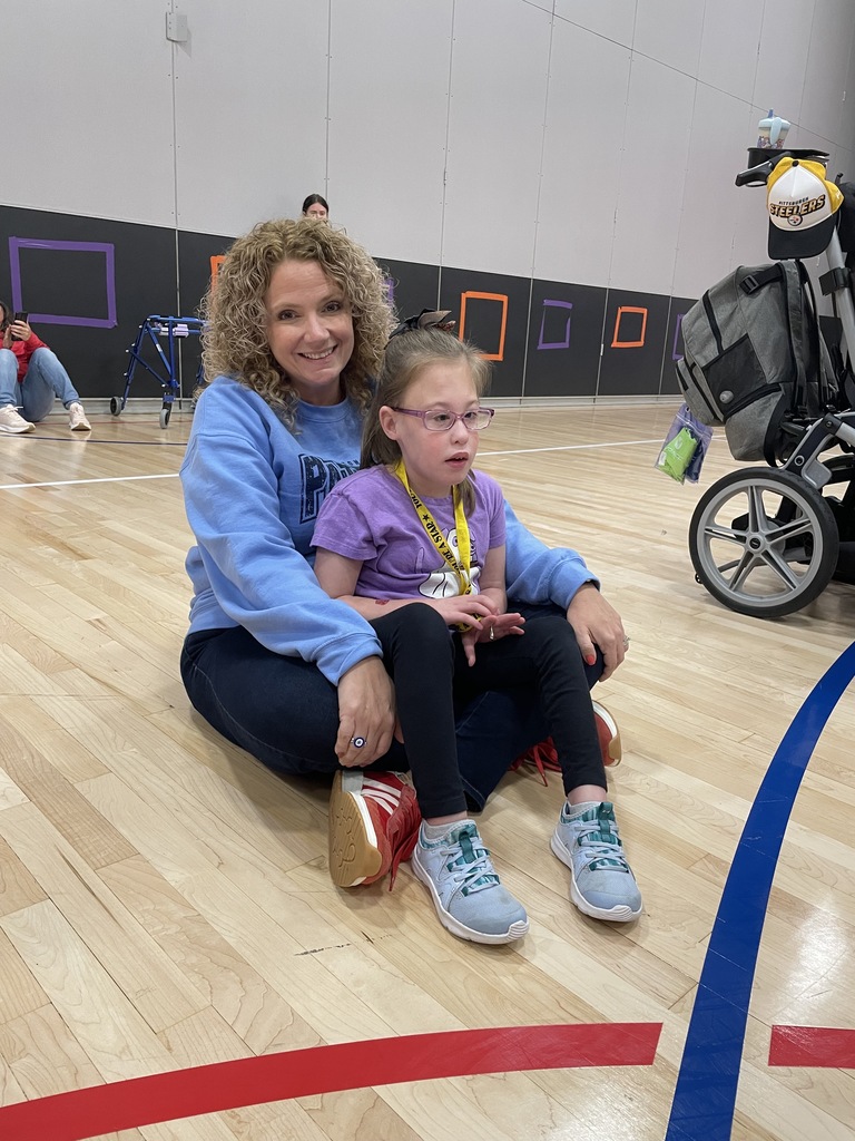 A group of students smiling at the camera holding donated items such jas paper towels, cleaning supplies and dog treats.
