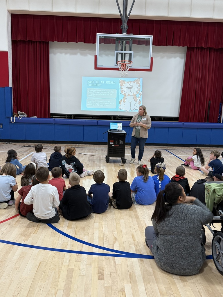 A group of students smiling at the camera holding donated items such jas paper towels, cleaning supplies and dog treats.