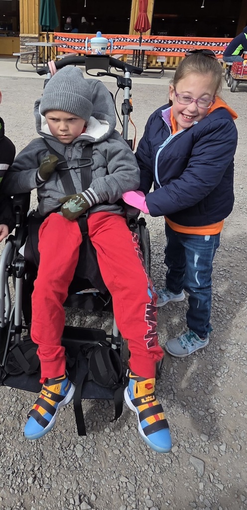 Kids at an apple orchard smiling.
