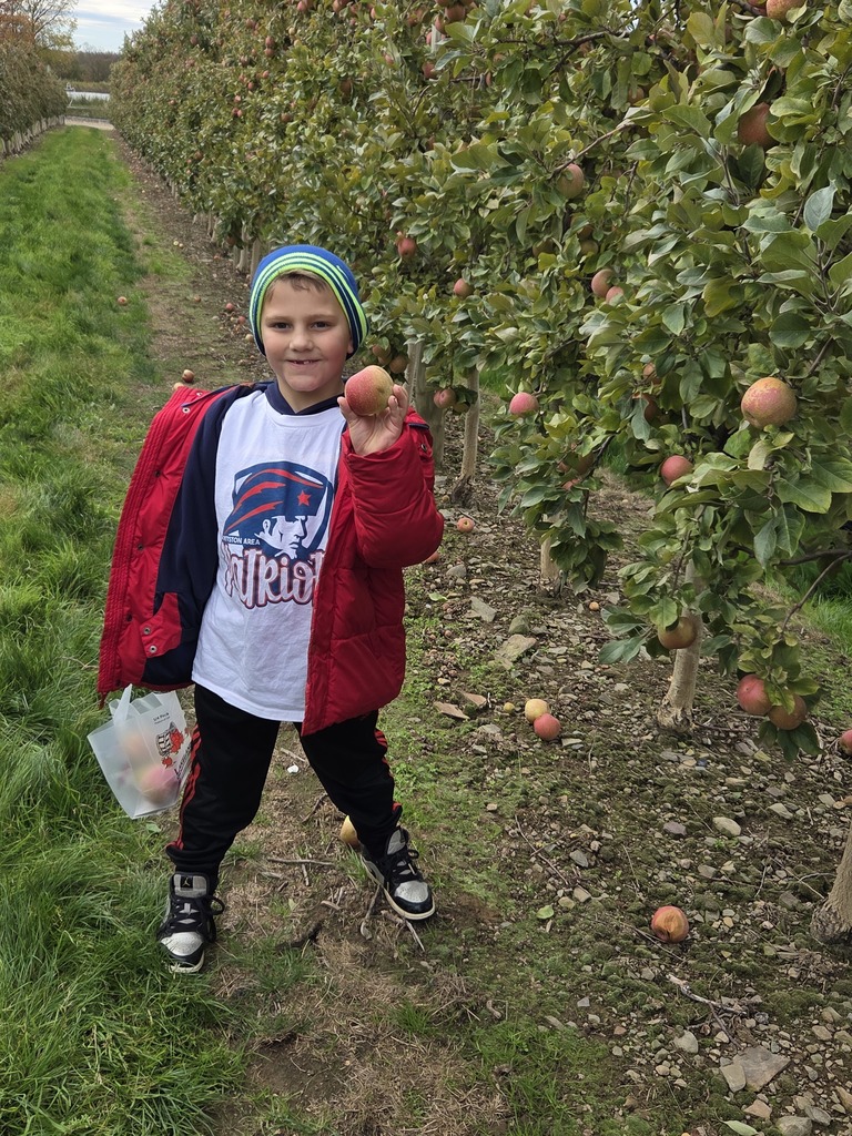 Kids at an apple orchard smiling.