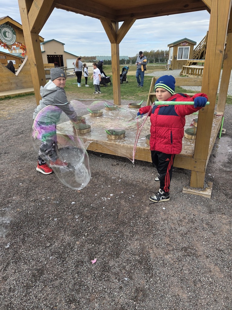 Kids at an apple orchard smiling.
