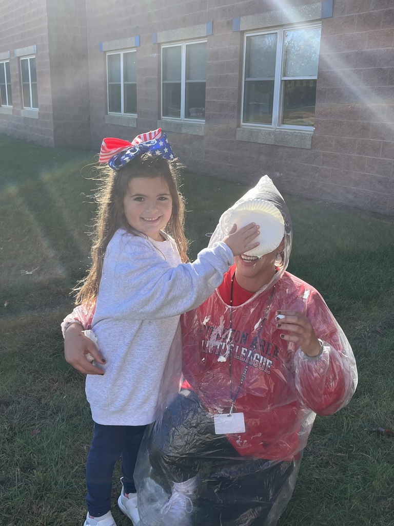 A girl putting a pie in a teachers face,