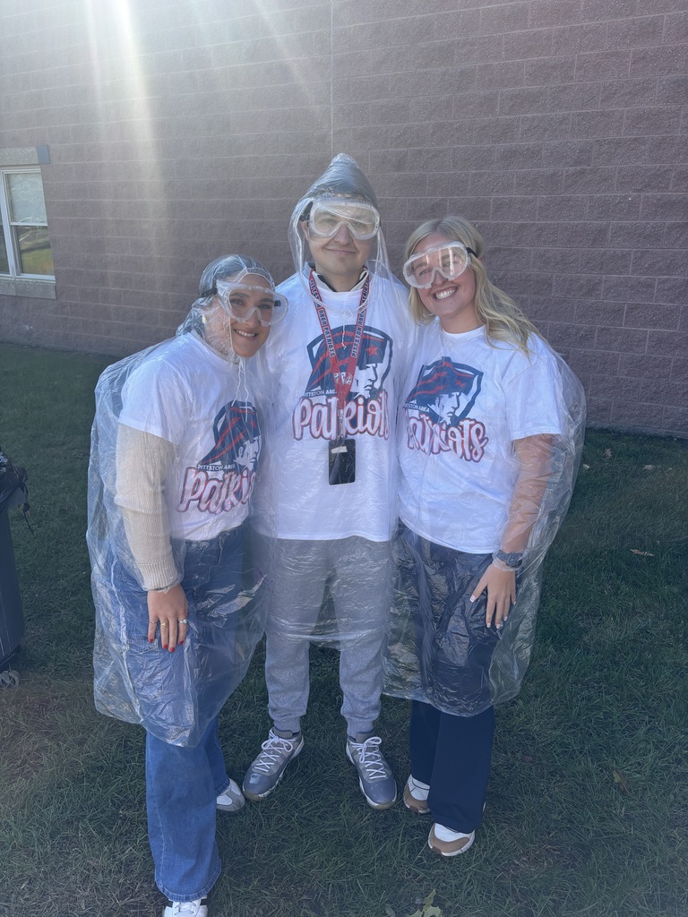 Three teachers in clear ponchos and goggles.