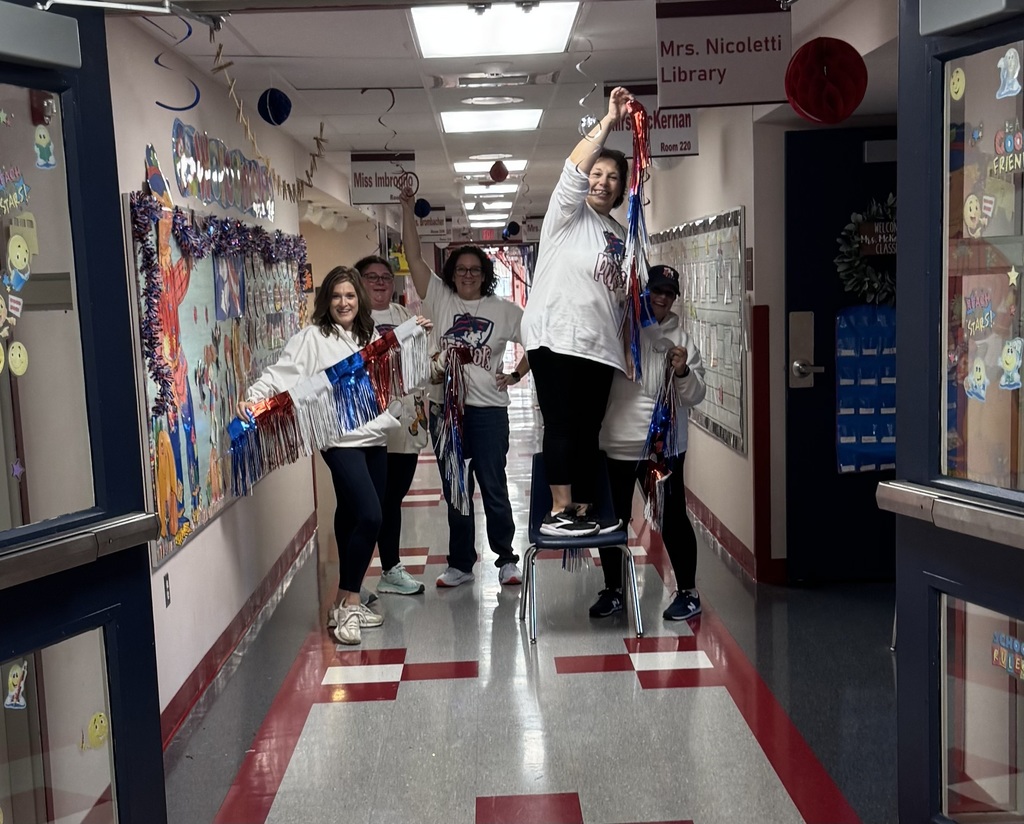 Teachers decorating a hallway with red and blue decorations.