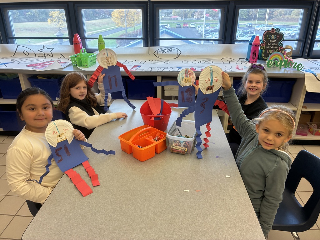 Students holding up a football player craft