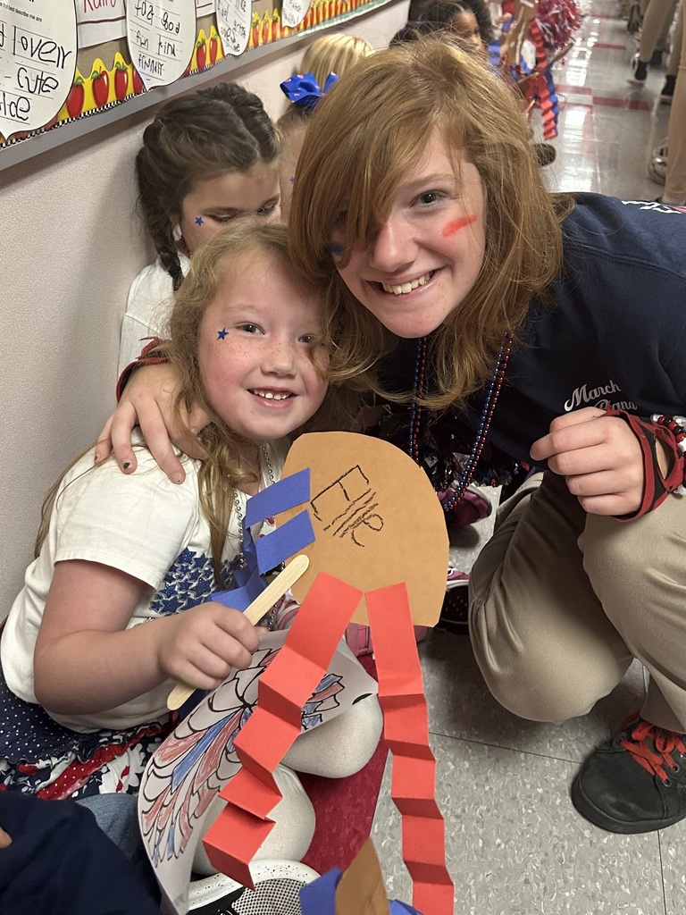 An older and younger sister smiling at the camera.