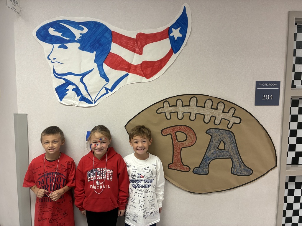 Three students in pittston area football shirts in front of football signs.