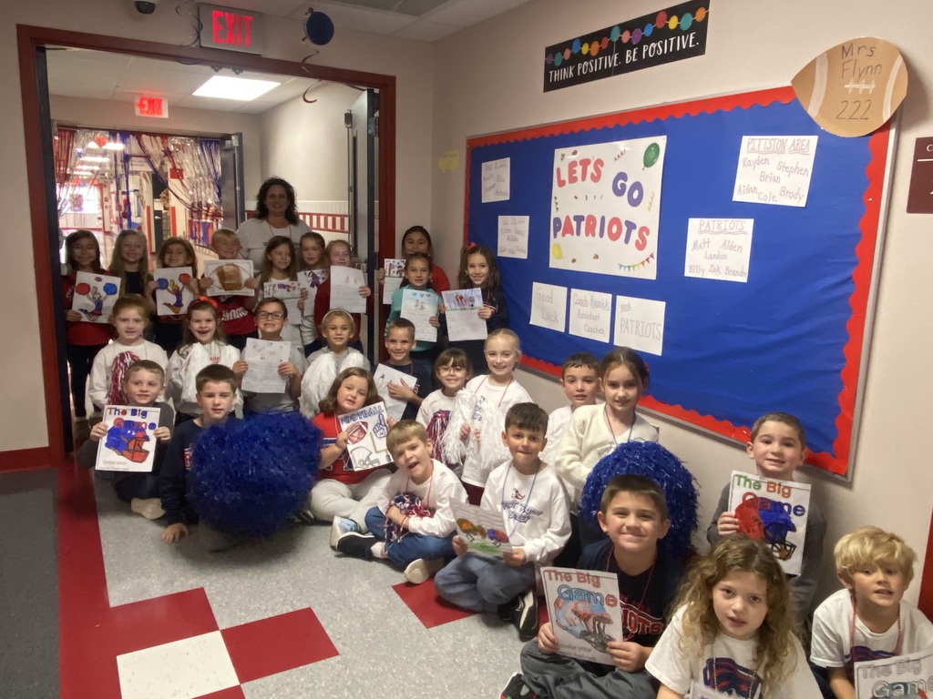 Students holding red and blue football signs in a school hallway.