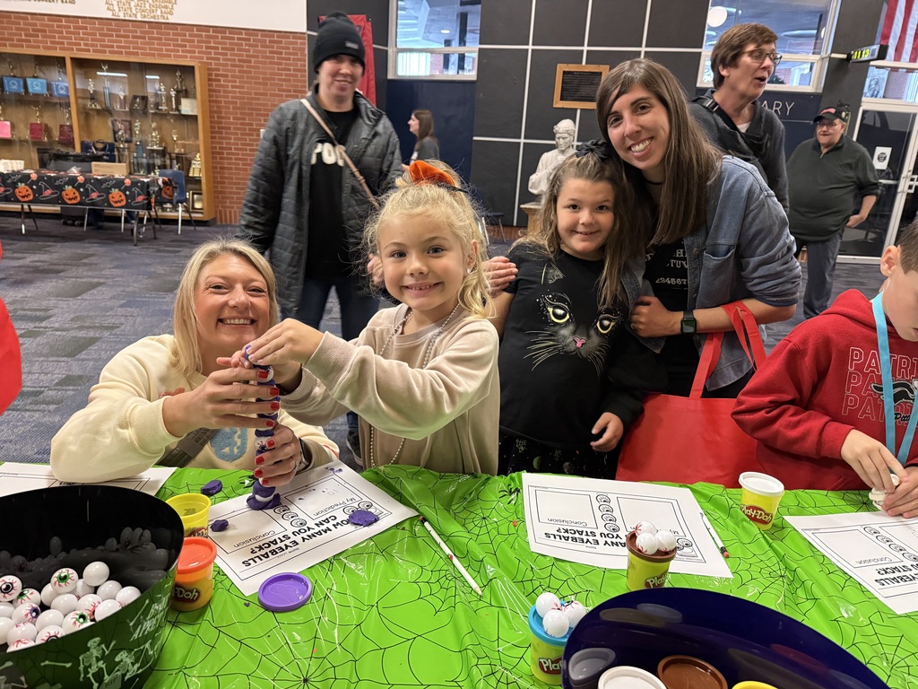 Families at a activity table in the high school lobby.