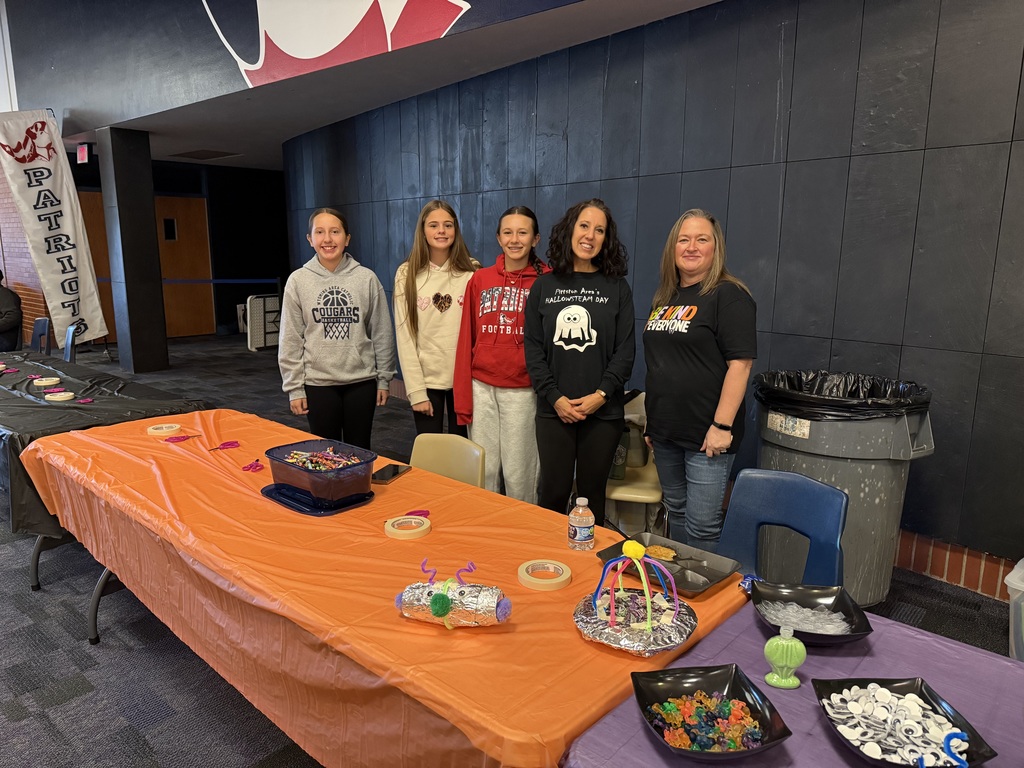 Teachers at a activity table in the high school lobby.
