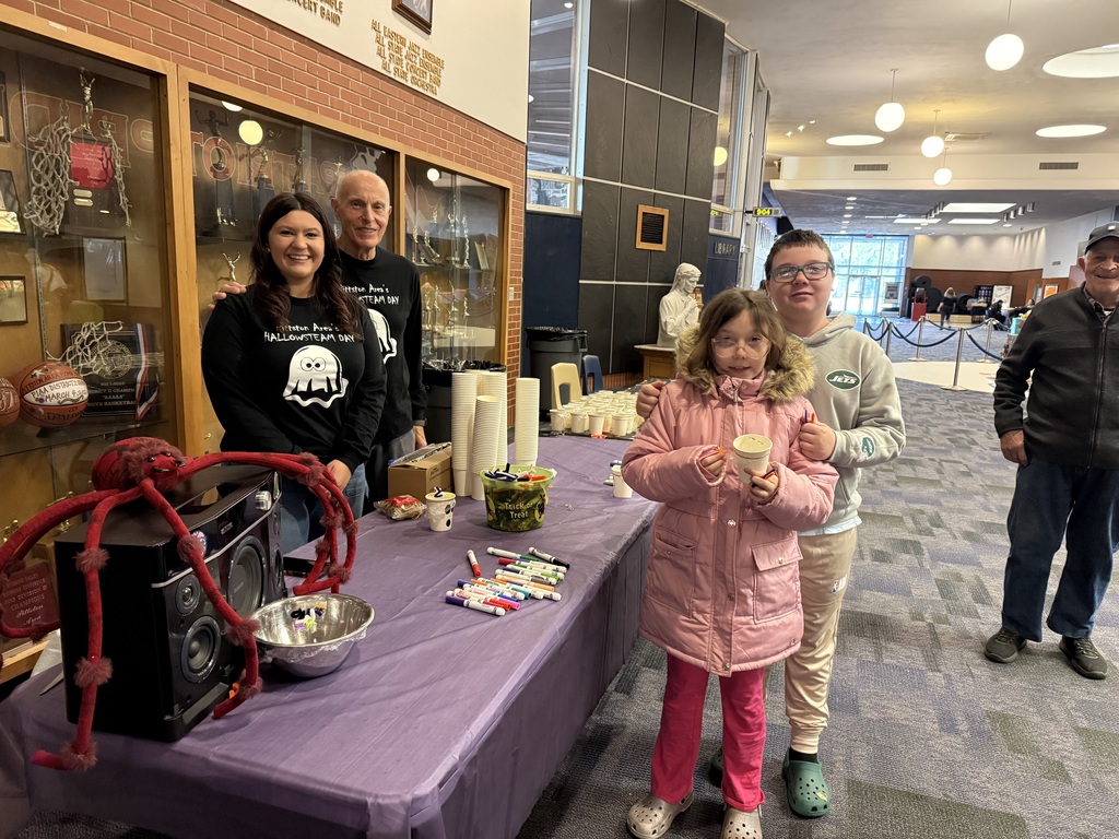 Teachers at a activity table in the high school lobby.