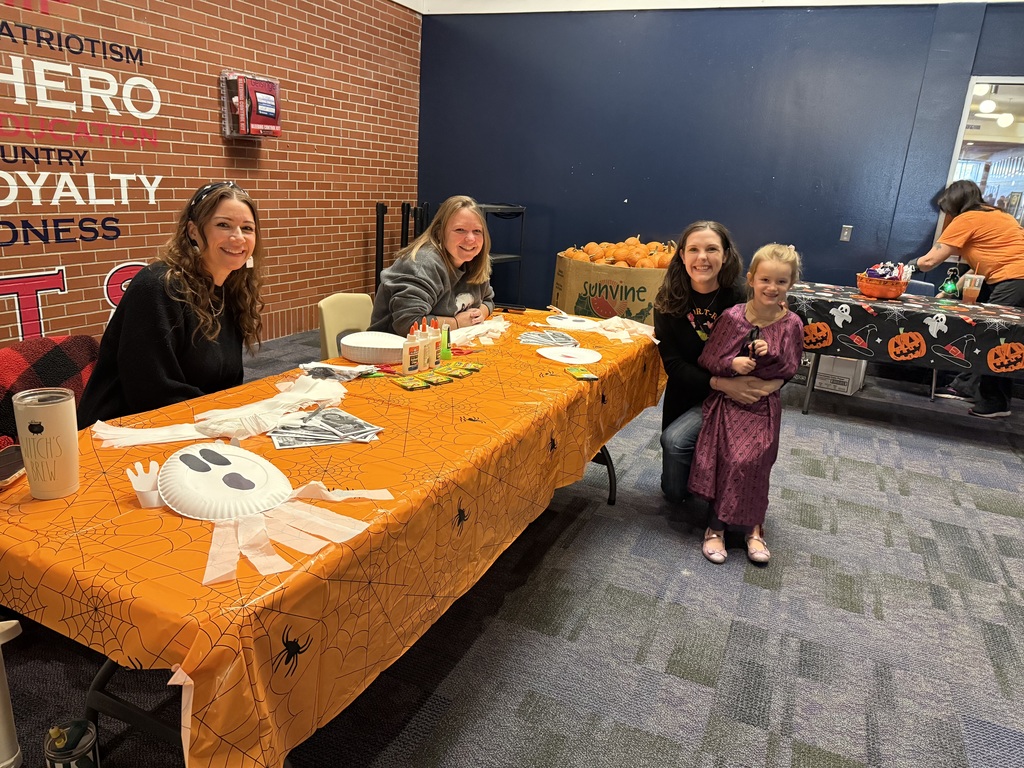 Teachers at a activity table in the high school lobby.